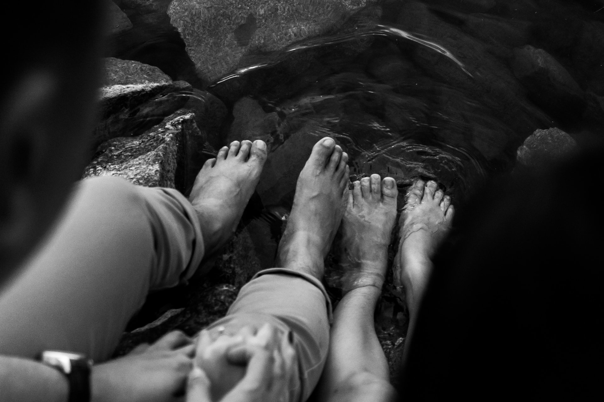 Grayscale photo of feet in water